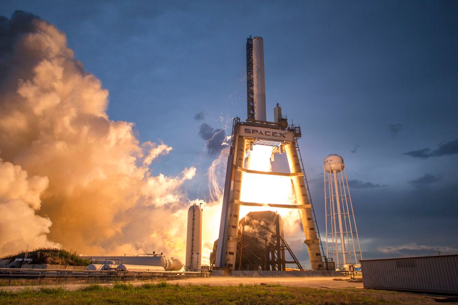 A SpaceX rocket standing vertically on a launch pad against a dusk sky, representing the aerospace company whose IPO reshaped 2026 equity markets.
