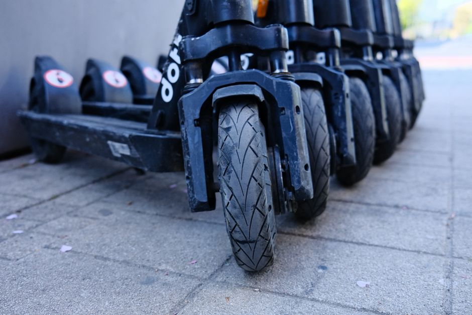 Row of parked electric scooters on a city sidewalk, representing Lime's micromobility rental platform ahead of its IPO