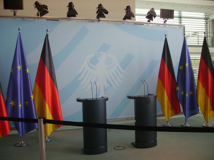 Empty podiums with German and EU flags in a government chancellery building