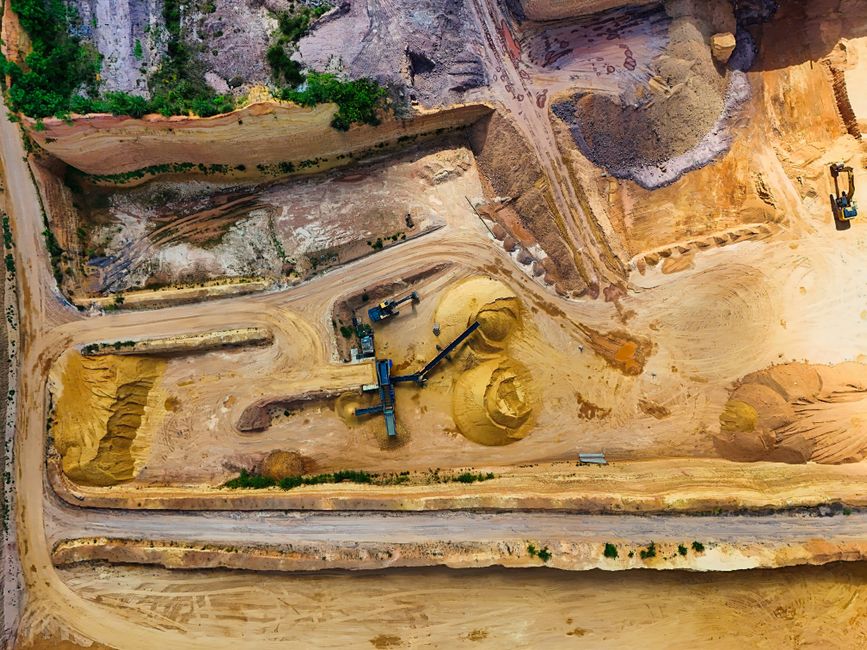Aerial view of an industrial quarry with heavy machinery extracting and processing raw materials.