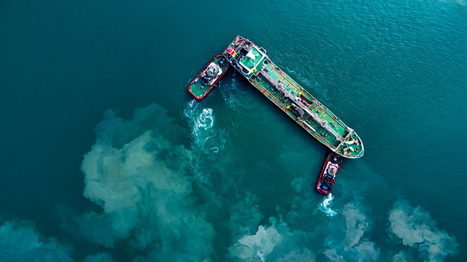 Cargo ship and tugboats navigating a busy maritime channel