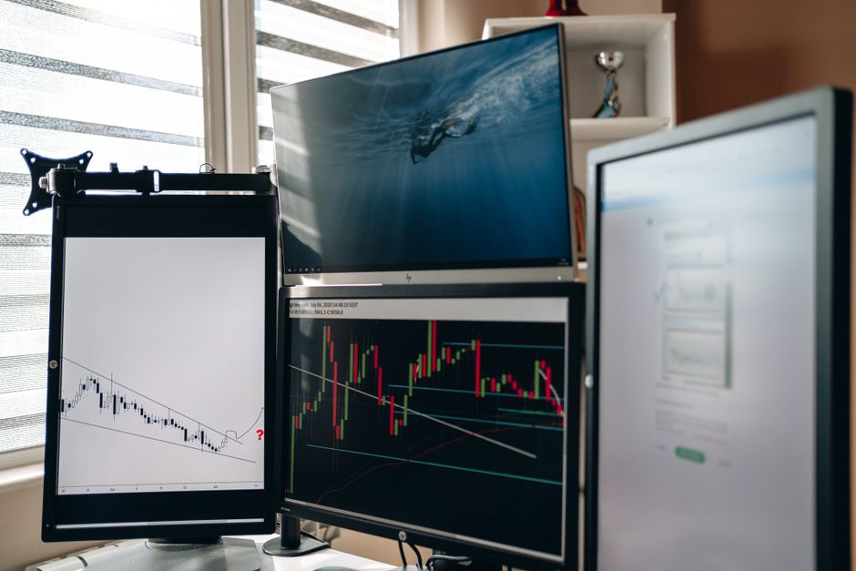 Multiple monitors displaying financial market data and trading charts