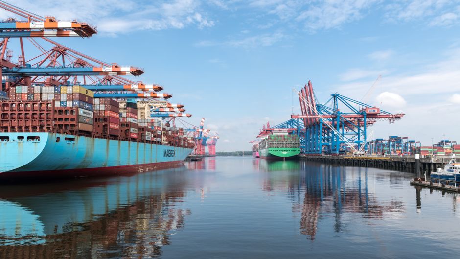 Large container ships docked at a commercial port, illustrating global maritime trade through critical shipping lanes.