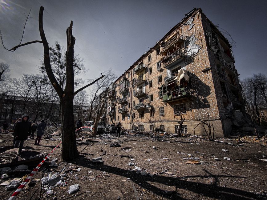 War-damaged residential building with blown-out walls and debris