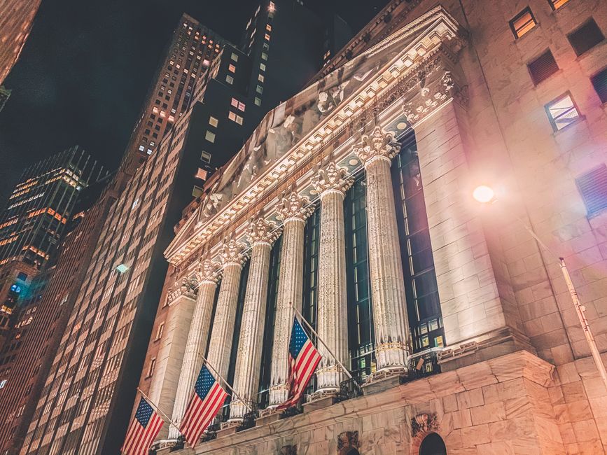 Nighttime view of the New York Stock Exchange building facade illuminated in Manhattan